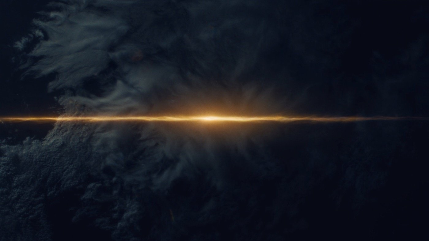 La ruta de luz cruzando un velo de nubes que se enciende de dorado al paso.